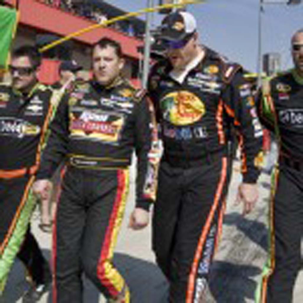 A very angry Tony Stewart (second from left) is escorted from the pits after a post-race altercation with Joey Logano. Photo by Daniel Knighton