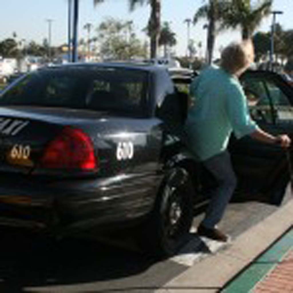 Oceanside senior Greg Smith boards a taxi driven by Donnie Aldridge. Aldridge said the taxi script program gives seniors more freedom. Photo by Promise Yee