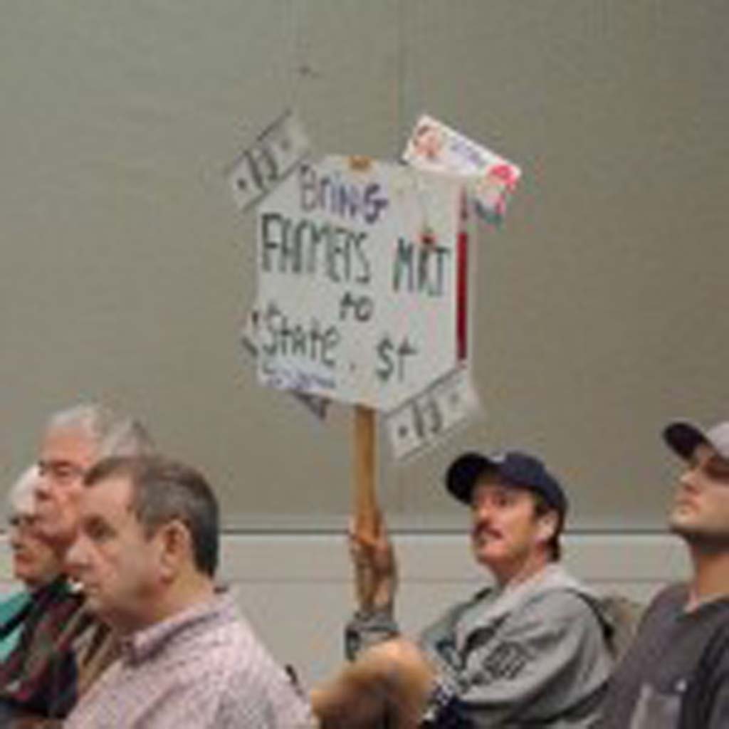 Carlsbad resident and business owner Jim Clark holds a sign at the May 15 Planning Commission meeting in support of relocating the city farmers market to State Street. “This will liven up this dead city,” he said during public comments. Photo by Rachel Stine