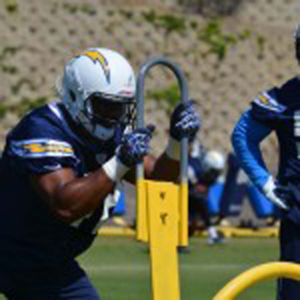 Rookie linebacker Devan Walker hits the sled as second year linebacker Melvin Ingram watches on. Photo by Tony Cagala