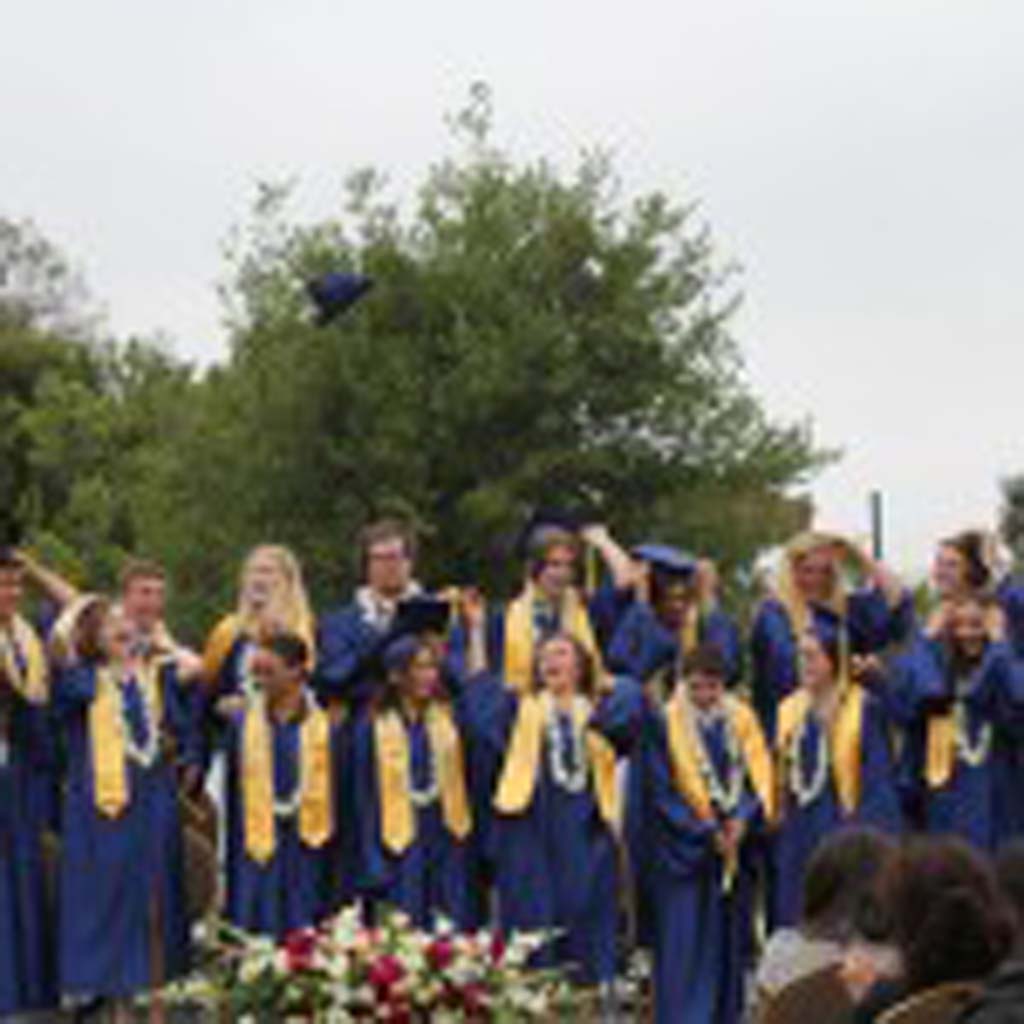 The Grauer School Class of 2013 throws mortarboard caps into the air upon graduation. Photo/ Traci Kitaoka