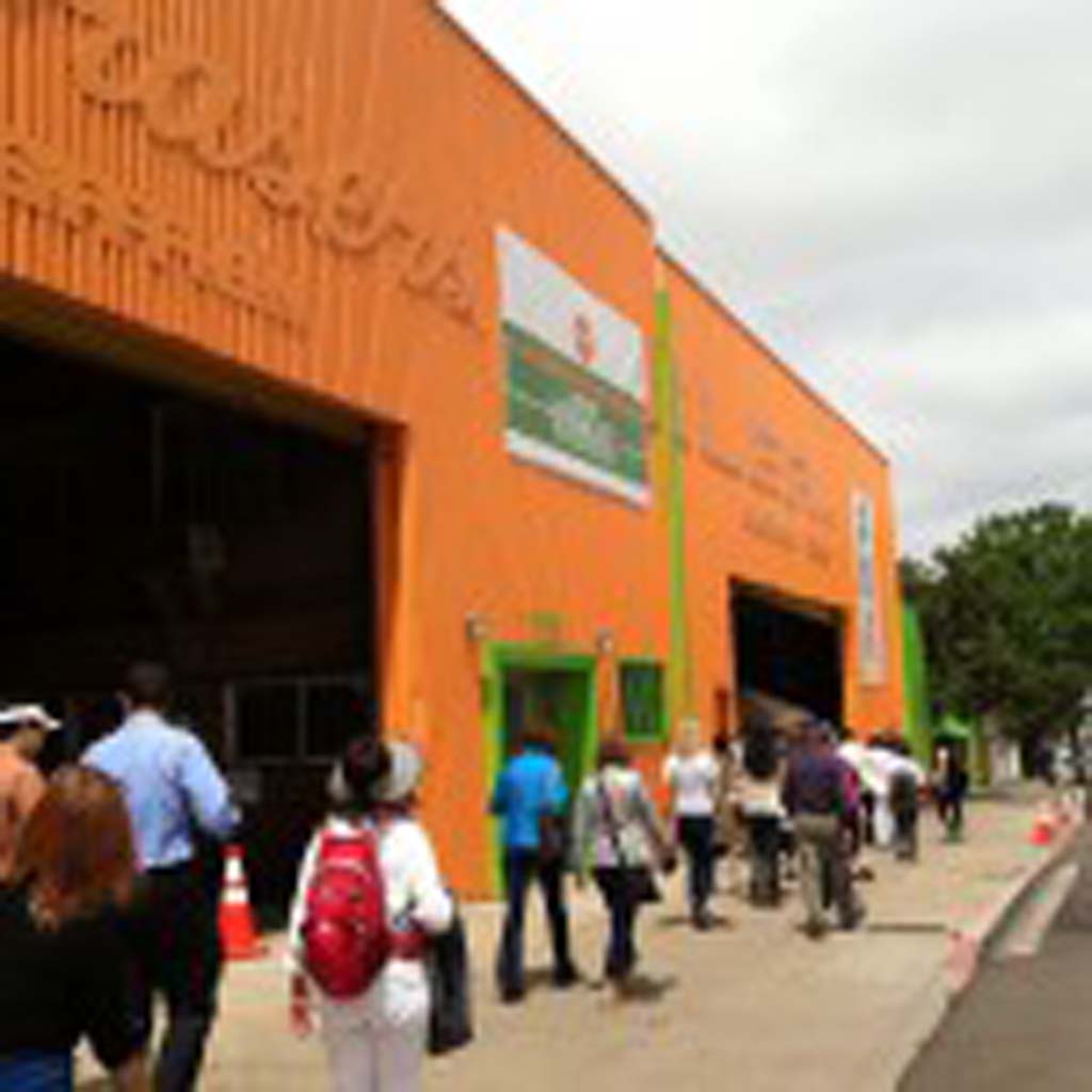 Members of the San Diego Professional Tour Guide Association are led to this renovated industrial building in Barrio Logan that houses the new San Diego Public Market. It is one of many colorful enterprises popping up in the area. Other establishments include Ryan Bros. Coffee, the Northgate Market and the Blueprint Café, housed next to an architect’s office. Barrio Logan is one of San Diego’s oldest neighborhoods. [Photo by E’Louise Ondash]