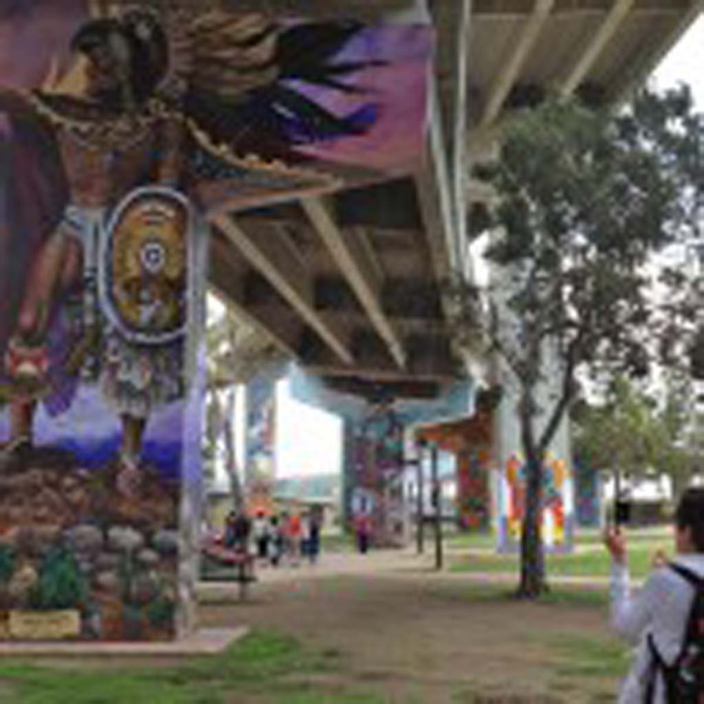 Chicano Park, created under the east-west approach ramps of the San Diego-Coronado Bay Bridge, is home to more than 50 murals that were painted mostly from 1973 to 1989. Earlier this year, and after many years of advocacy, the murals were placed on the National Register of Historic Places. Chicano Park took shape after a few hundred community residents stood up to bulldozers in April 1970. The state wanted to build a California Highway Patrol substation, but the city had previously promised the land for a neighborhood park. The murals draw people from the world over. [Photo by Laurie Brindle]