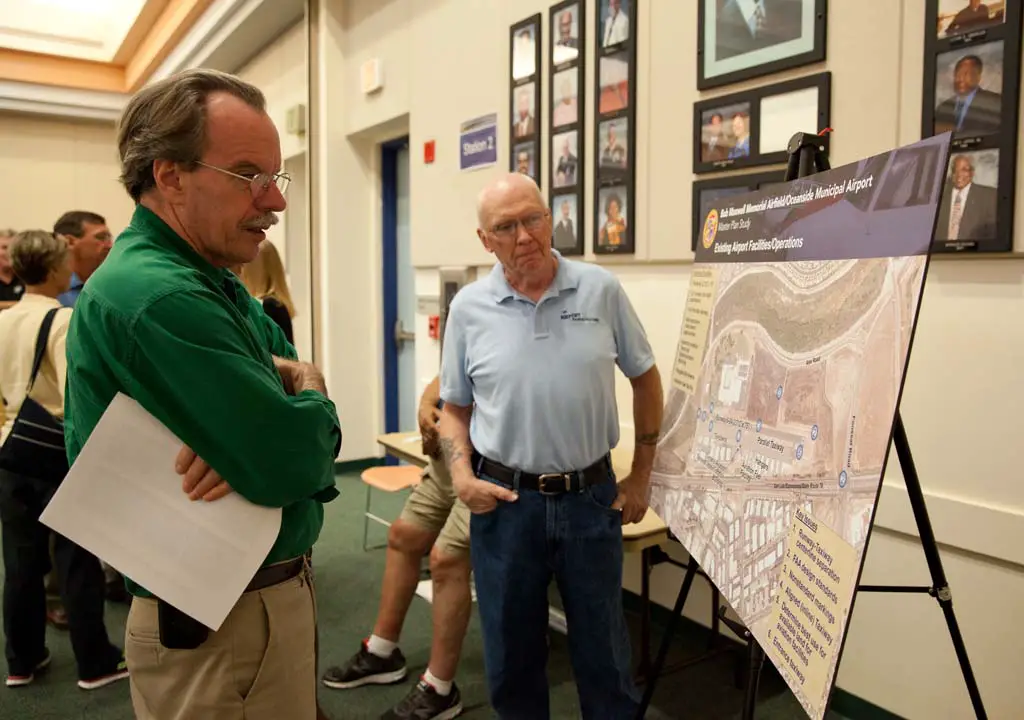 Airport Manager Dennis Easto discusses improvements to the Bob Maxwell Memorial Airfield with Oceanside Resident David Terrell. The city hosted an open house at the Oceanside Public Library on Wednesday to get feedback from the community about the master plan. Photo by Paige Nelson