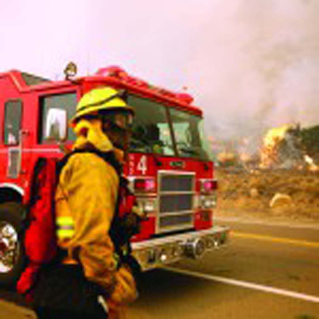 Scott Eugene from San Diego Fire Engine No. 4 accesses the situation during the Witch Creek fire in 2007. Fire fees intended to finance fire prevention services carried out by Cal Fire have resumed billing. File photo by Todd LeVeck