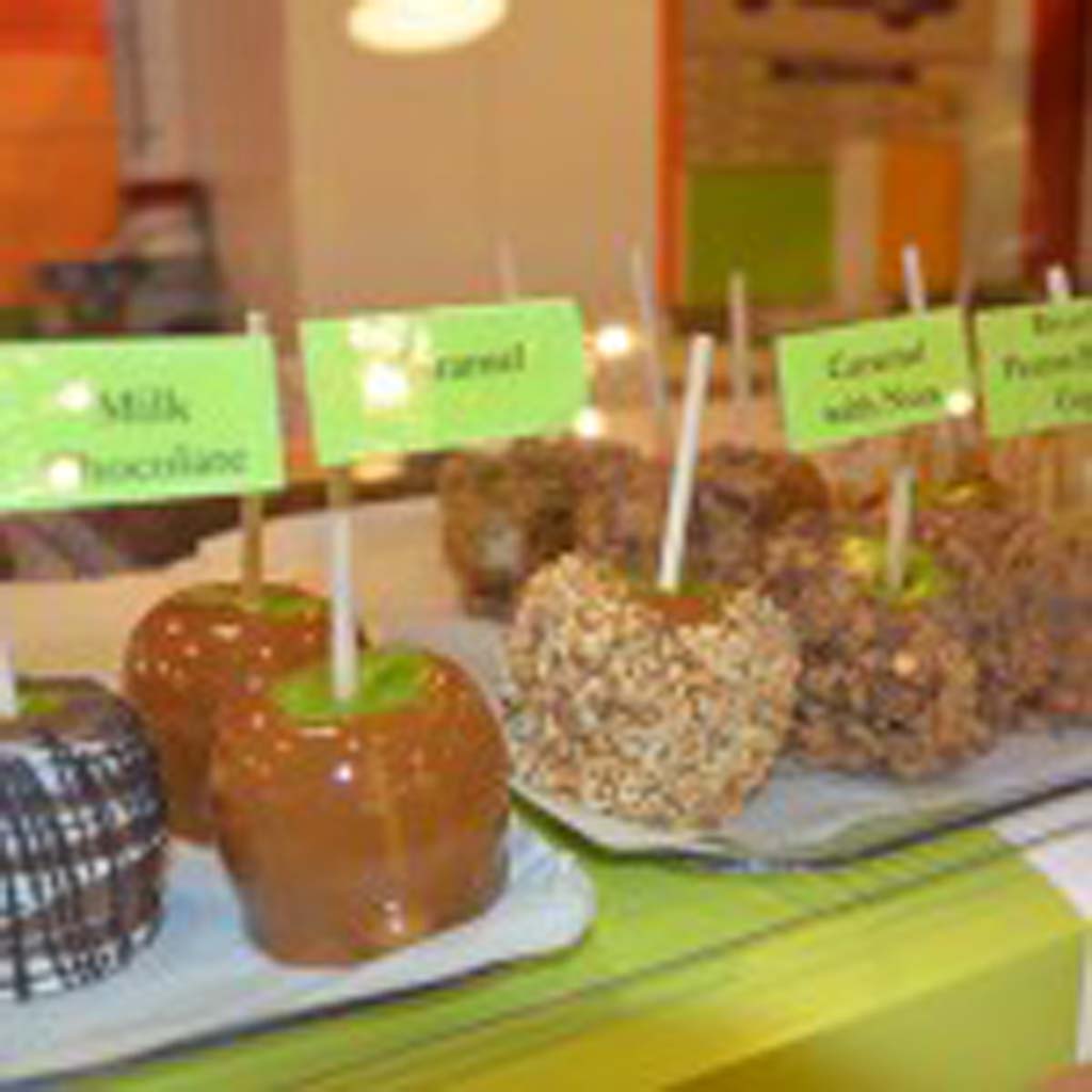 Gourmet candy apples, covered in all manner of caramel, nuts, chocolate and peanut butter cups, line the counters at Old Town Sweet Shop on Temecula’s Front Street. The shop makes about 200 apples a week, spreading the task out over two days. It takes about six hours to produce 100, according to chief candy apple maker Gina Cannella. (Photo by E’Louise Ondash)