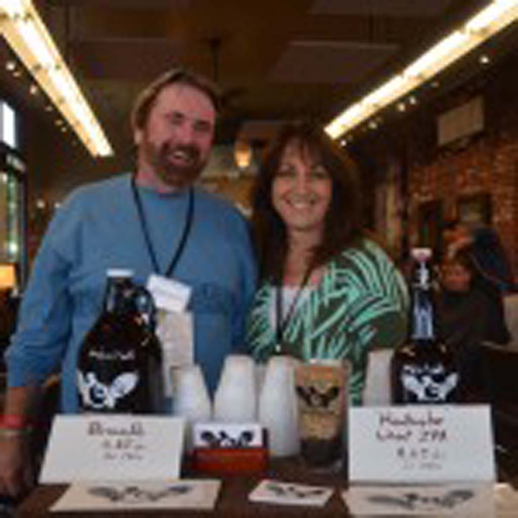 Tom Vogt, left, and Brenda Smith with Arcana Brewery, based in Carlsbad, host a sip station inside Detour Salon, offering samples of the brewery’s India Pale Ale and Brown Ale.