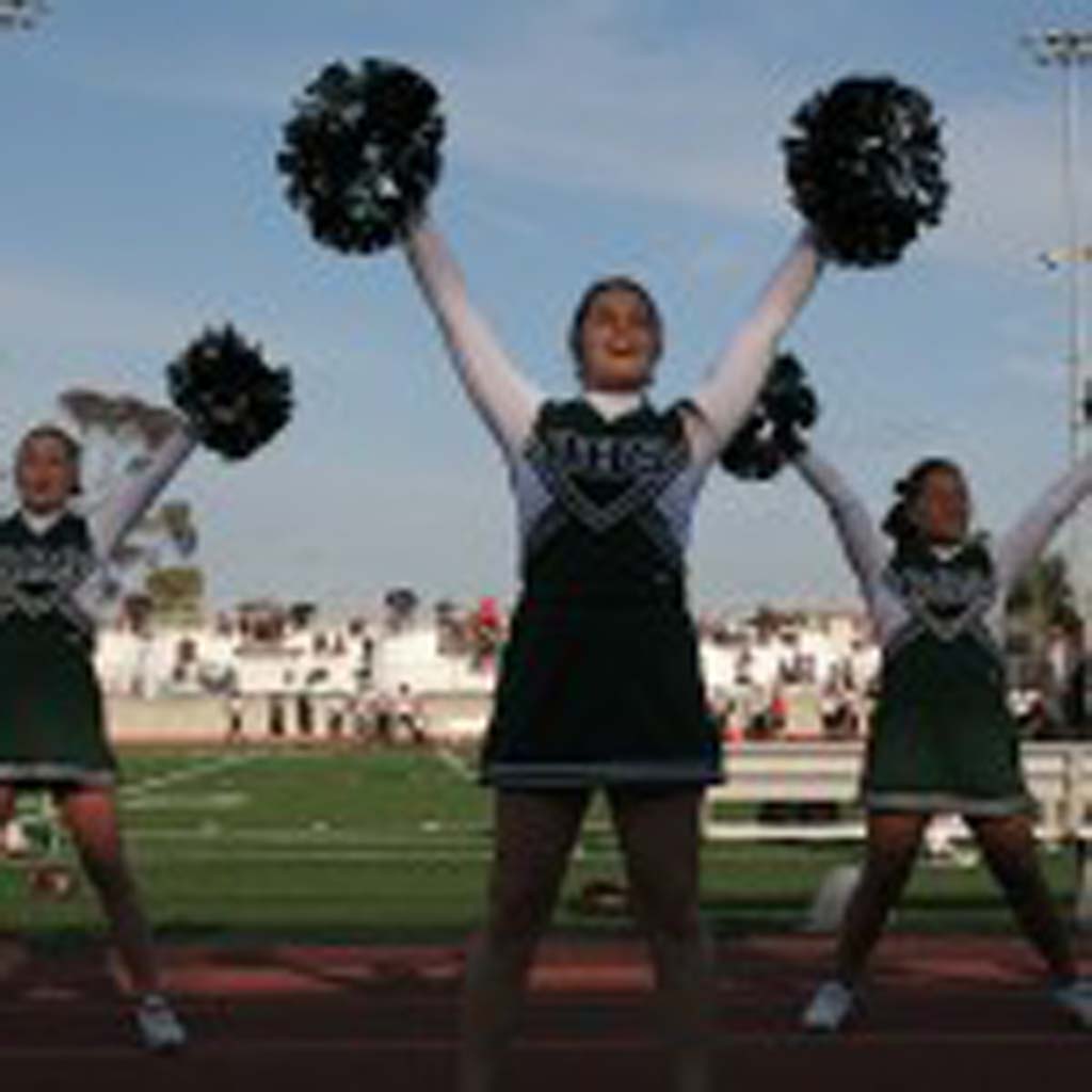 Krista Slade, center, cheers on the Oceanside team. Eight top high school teams faced off during the two-day football showcase. Photo by Promise Yee