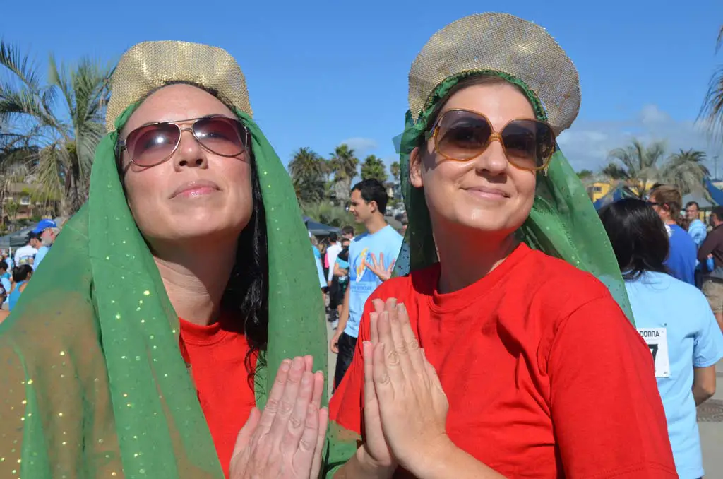 Erin Callaghan, left, and Holly Martin dress in the likeness of the Surfing Madonna during the inaugural Save the Ocean race at Moonlight Beach.