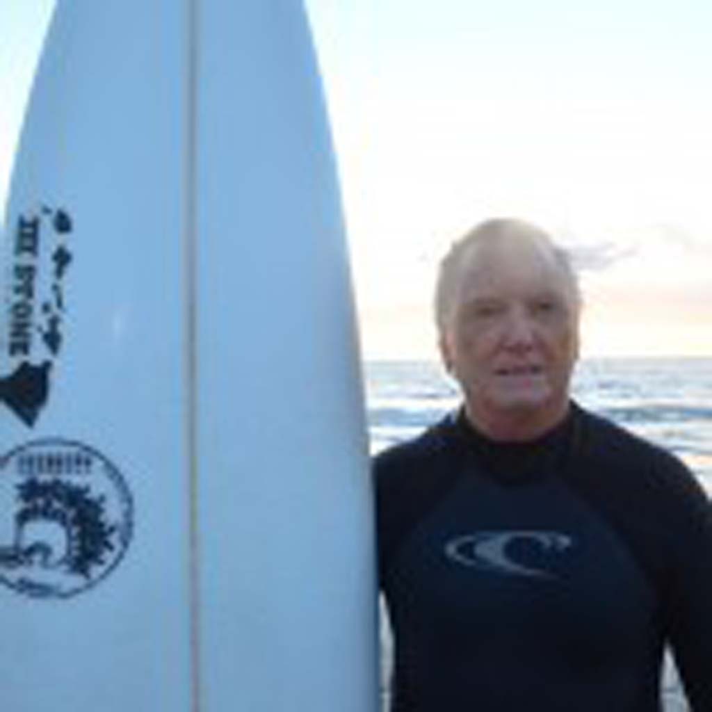 Dave Passmore uses one of his son’s surfboards at the paddle out.