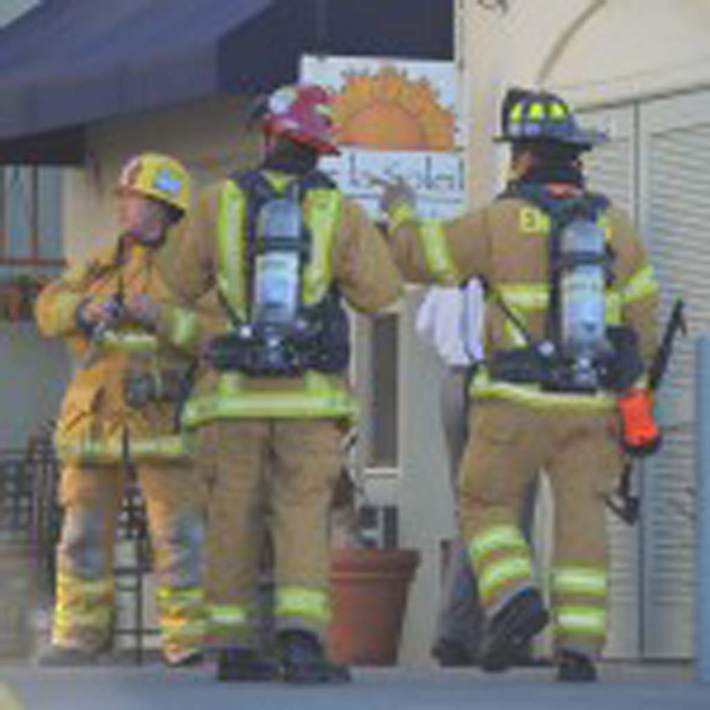 Firefighters from the Encinitas Fire Department examine the Moonlight Shopping Center after a grease fire started in a nearby restaurant. Photo by Tony Cagala