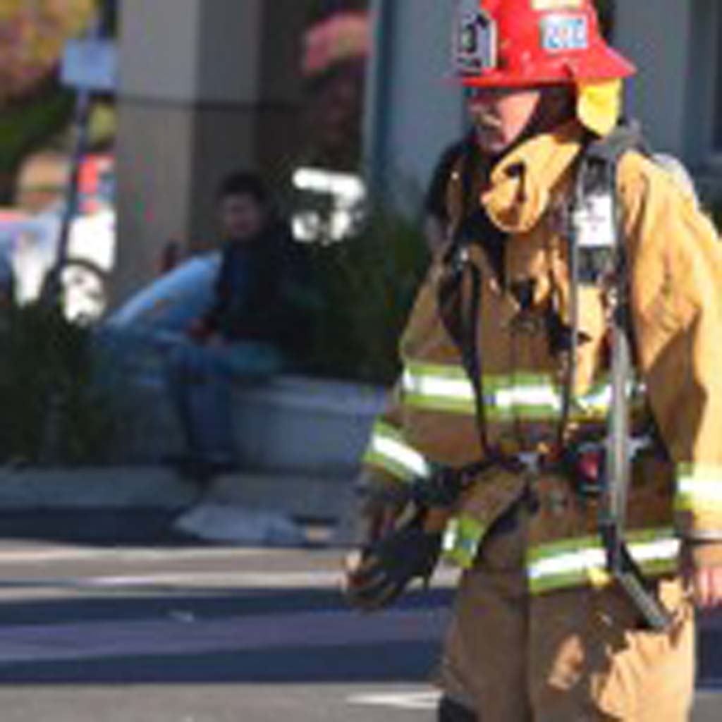An Encinitas Fire Department captain walks out of the El Callejon restaurant after a grease fire was cleared. Photo by Tony Cagala