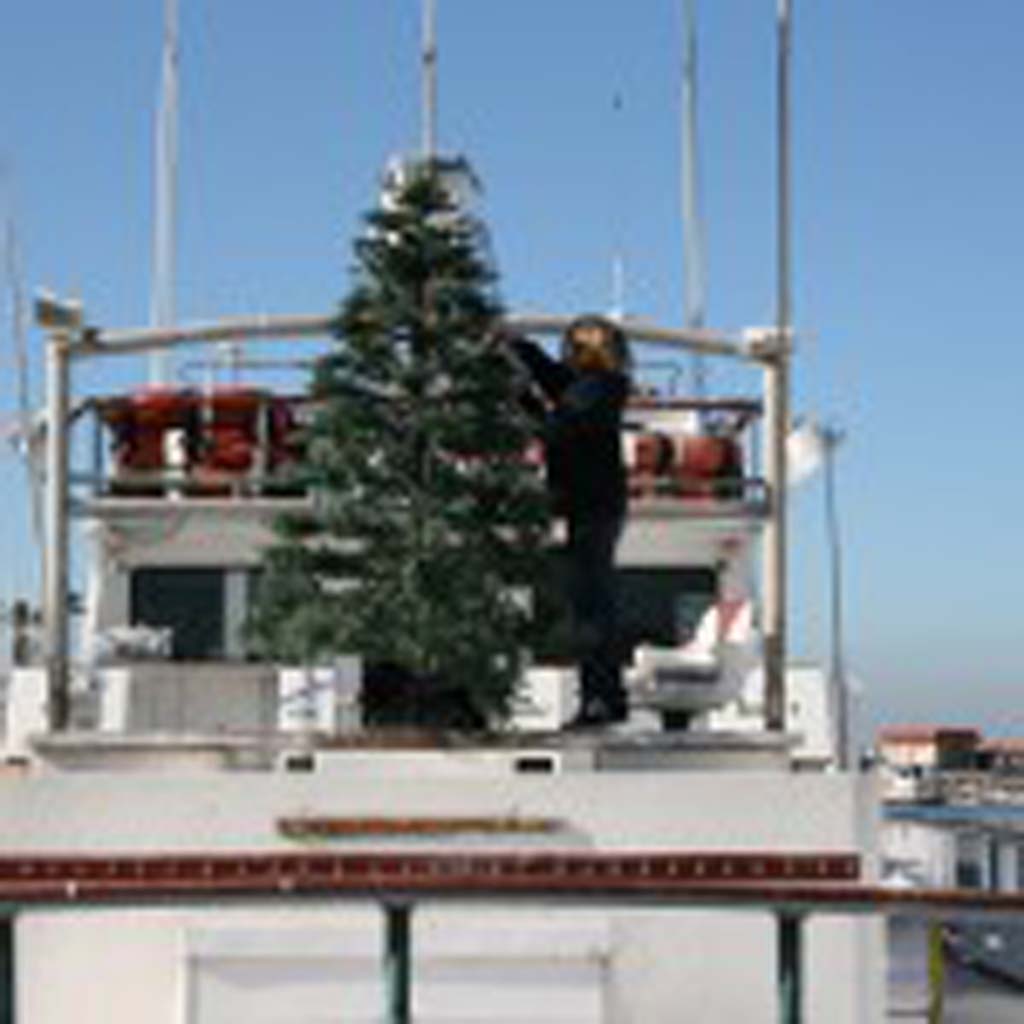 Channing Helgren, 11, decorates the Christmas tree aboard the Electra. The Parade of Lights is set to take sail Dec. 14. Photo by Promise Yee