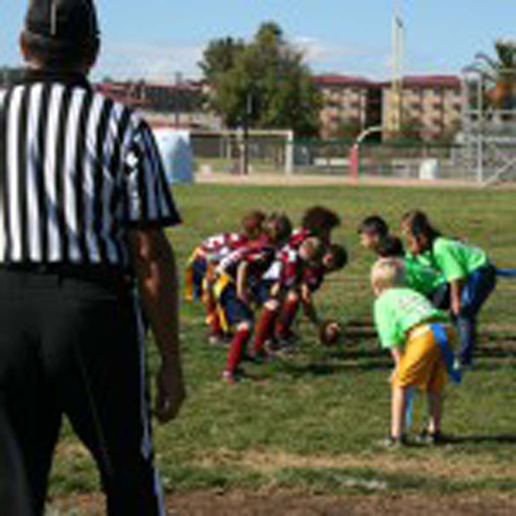 Boys and girls flag football teams face off. The Buddy Bowl allows military and nonmilitary communities to connect. Photo by Promise Yee