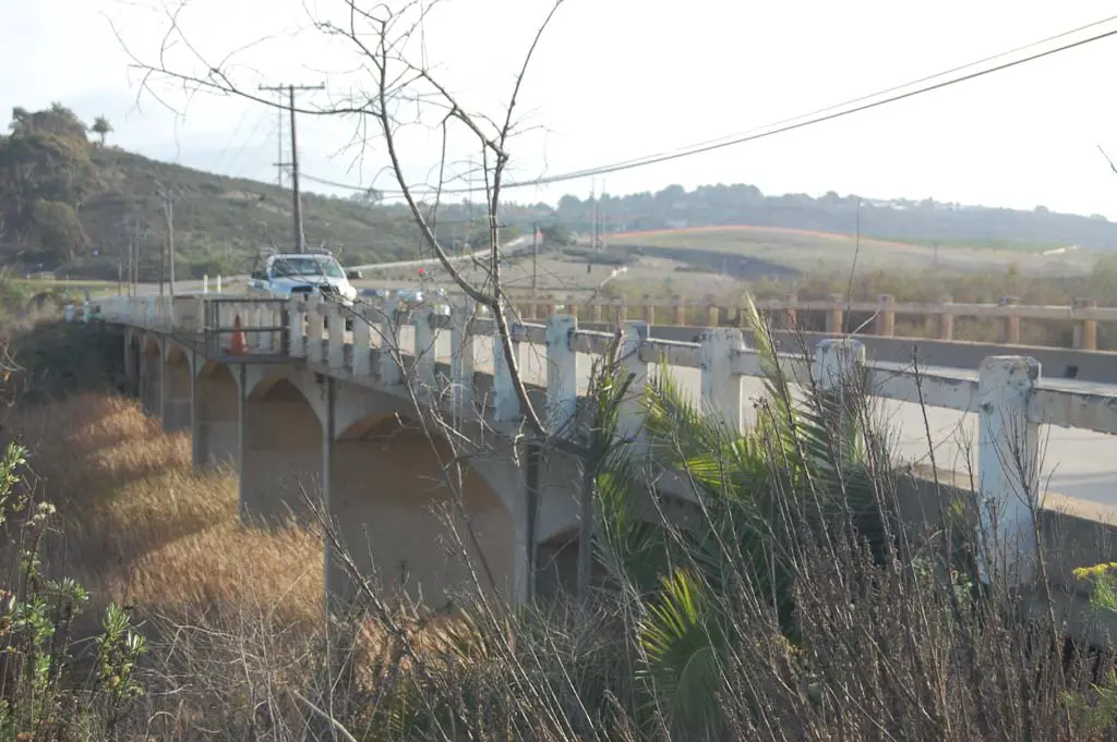 The narrow bridge on El Camino Real, deemed “structurally inefficient,” will be replaced with a four-lane structure, but not for at least another three years. Photo by Bianca Kaplanek