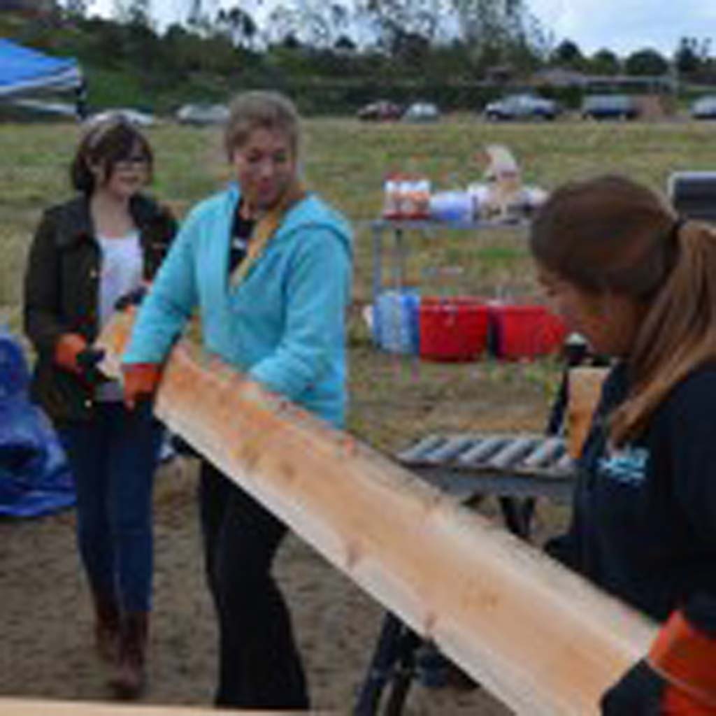 Left to right: Gabriella Garruto, Julia Ramzi and Maria Lopez move a wood slat that will make up a planter box.