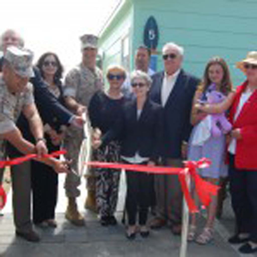 Bob Clelland, chairman of the Pendleton Cottages Project, left, donors and their families and Brig. Gen. John Bullard, commanding general of Marine Corps Base Camp Pendleton, take part in the ribbon-cutting ceremony. Photo by Bianca Kaplanek