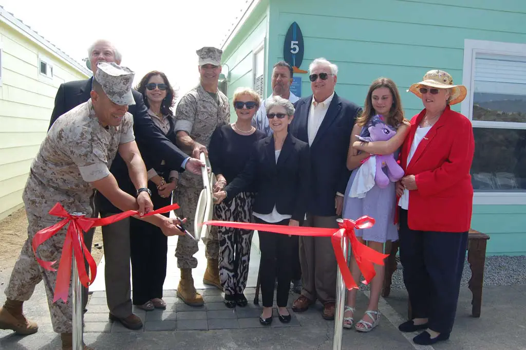 Bob Clelland, chairman of the Pendleton Cottages Project, left, donors and their families and Brig. Gen. John Bullard, commanding general of Marine Corps Base Camp Pendleton, take part in the ribbon-cutting ceremony. Photo by Bianca Kaplanek