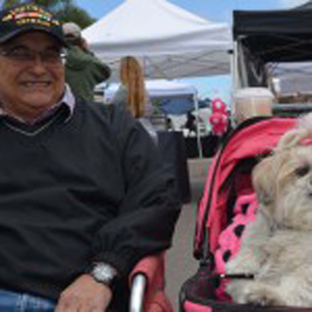 Tony Banzuelo sits with Daisy Mae, a Shih Tzu AKC Canine Good Citizen and pet therapy dog with Therapy Dogs International (TDI). Photo by Tony Cagala
