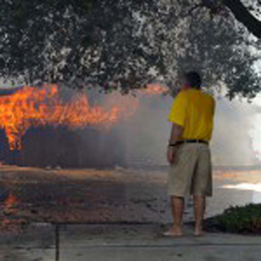 Greg Saska watches his home burn on Skimmer Court on Tuesday. Photo by Jared Whitlock