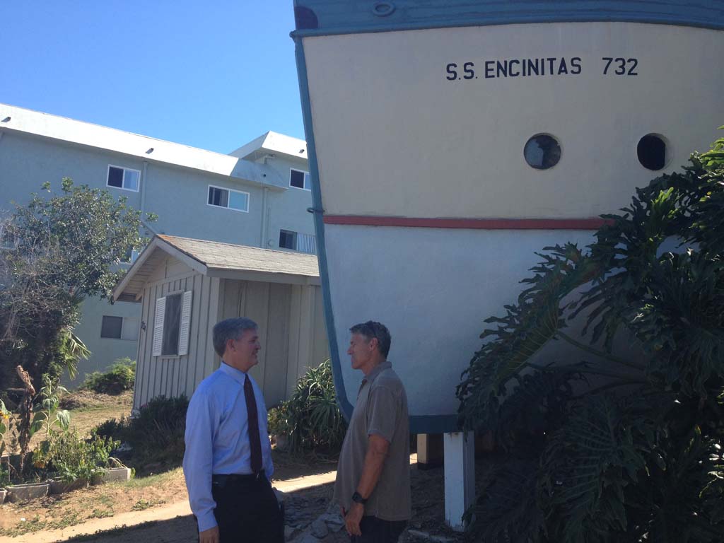San Diego County Supervisor Dave Roberts, left, talks with Tom Cozens, founder of the Encinitas Preservation Association on Tuesday outside the well-known boathouses in Encinitas. Photo by Aaron Burgin