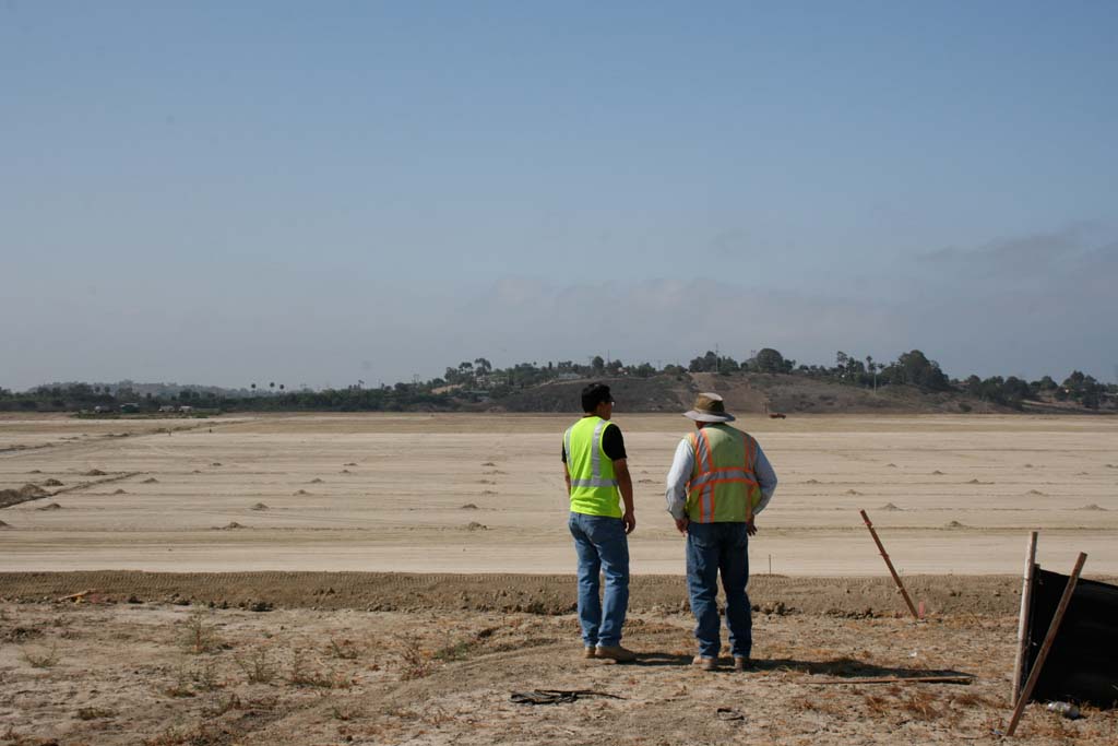 Abraham Chen, city associate engineer, left, looks out over site of 22 soccer fields. Sod will be going in this month. Photo by Promise Yee