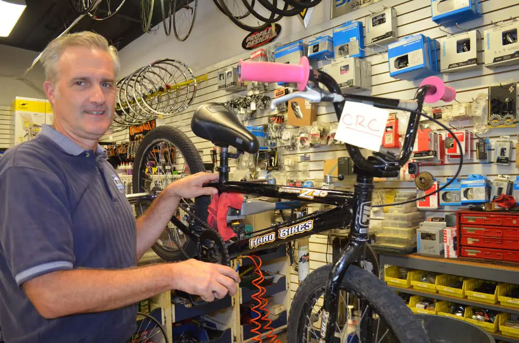 Co-owner of El Camino Bike Shop Will Schellenger is helping to refurbish old bikes that will be given to children of low-income families later this year. Photo by Tony Cagala