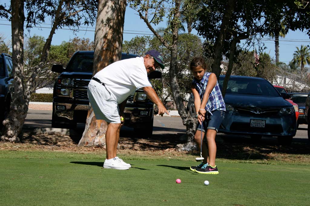 PGA golf pro Tito Hualde, left, holds a lesson with Ilima Haupu, 8, of Vista. The golf course is home to the North County Junior Golf Association. Photo by Promise Yee