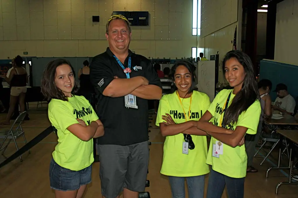 Vista Innovation and Design Academy Principal Eric Chagala, second from left, and seventh grade students Krisiana Humann, Destanae Torres, and Alena Kasiguran are ready to help students through the iPad check out process. Students check out iPads for the school year much like a library book. Photo by Promise Yee