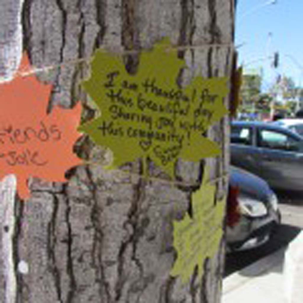 People are writing messages about what they’re thankful for on paper leaves and attaching them to the giving tree in Carlsbad. Photo by Ellen Wright