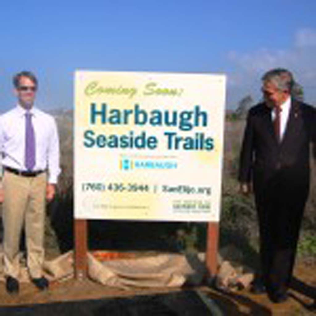 A sign announcing the new name for what has been called Gateway Park is unveiled during a Jan. 13 press conference by, from left, Solana Beach Mayor Lesa Heebner, San Elijo Lagoon Conservancy Executive Director Doug Gibson, County Supervisor Dave Roberts and Joe Balla, director of the George and Betty Harbaugh Charitable Foundation. Photo by Bianca Kaplanek