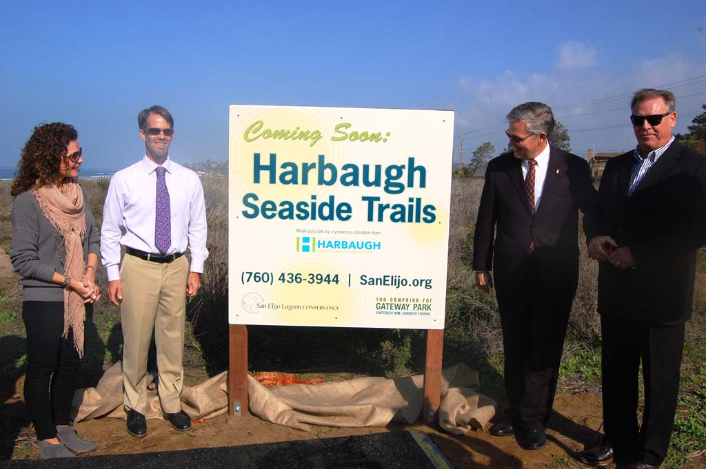 A sign announcing the new name for what has been called Gateway Park is unveiled during a Jan. 13 press conference by, from left, Solana Beach Mayor Lesa Heebner, San Elijo Lagoon Conservancy Executive Director Doug Gibson, County Supervisor Dave Roberts and Joe Balla, director of the George and Betty Harbaugh Charitable Foundation. Photo by Bianca Kaplanek