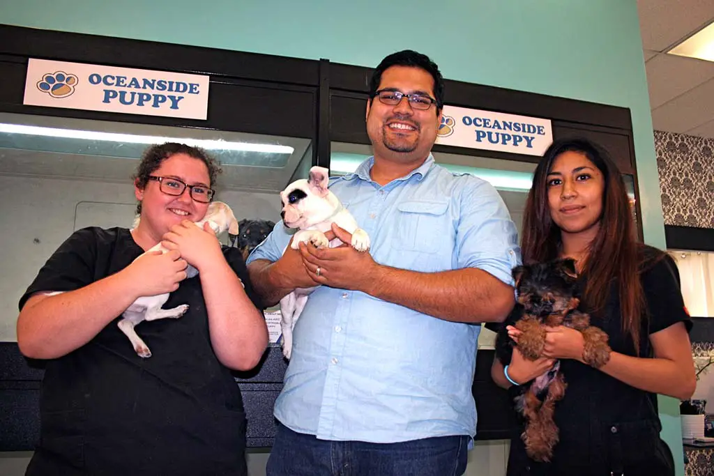 Oceanside Puppy owner David Salinas, center, said he would pursue legal action against the city. An Oceanside ordinance will close Oceanside Puppy unless the owner complies. File photo by Promise Yee