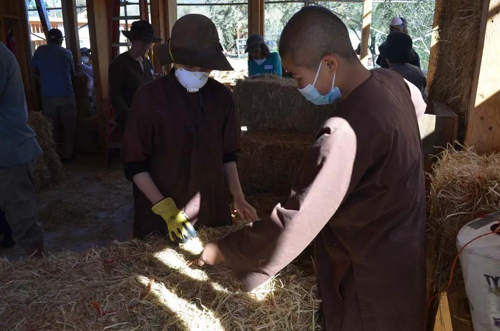 Zen Buddhist nuns at Deer Park Monastery help to build their new homes using straw bales. Photo by Tony Cagala
