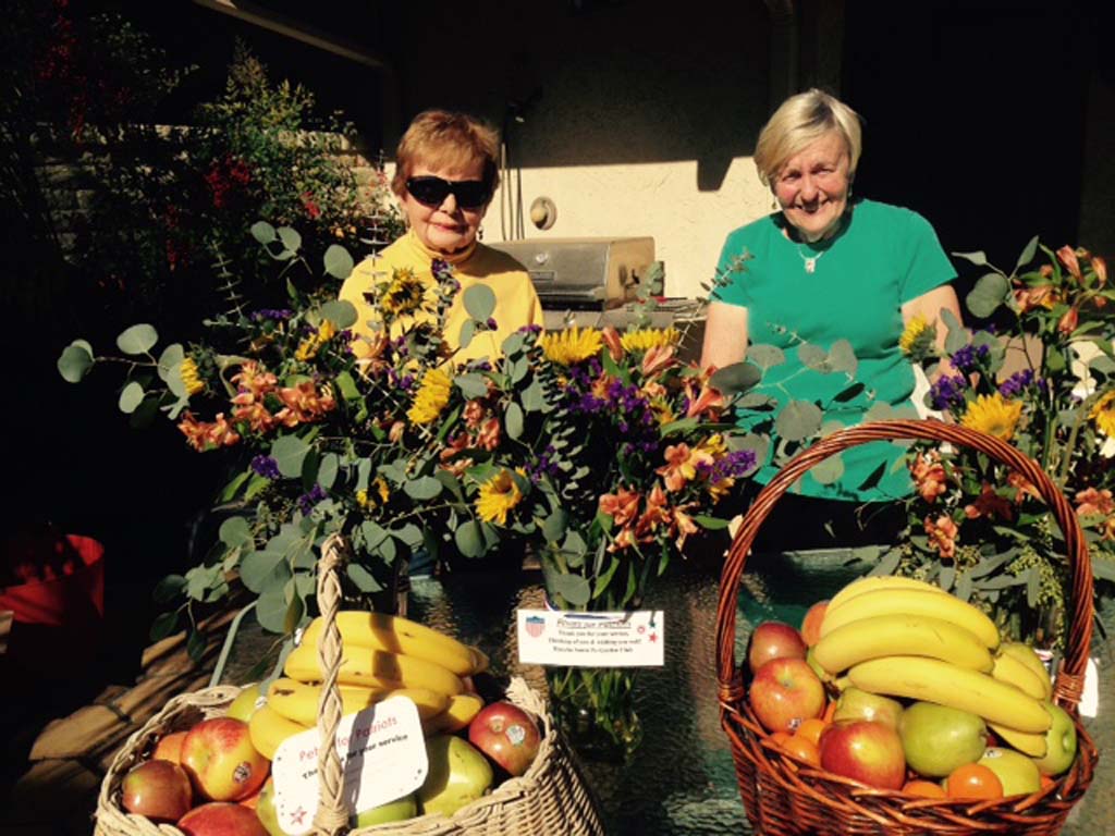 Rancho Santa Fe Garden Club members LaVerne Scholosser and Shirley Corless prepare floral arrangements and fruit baskets. Courtesy photo