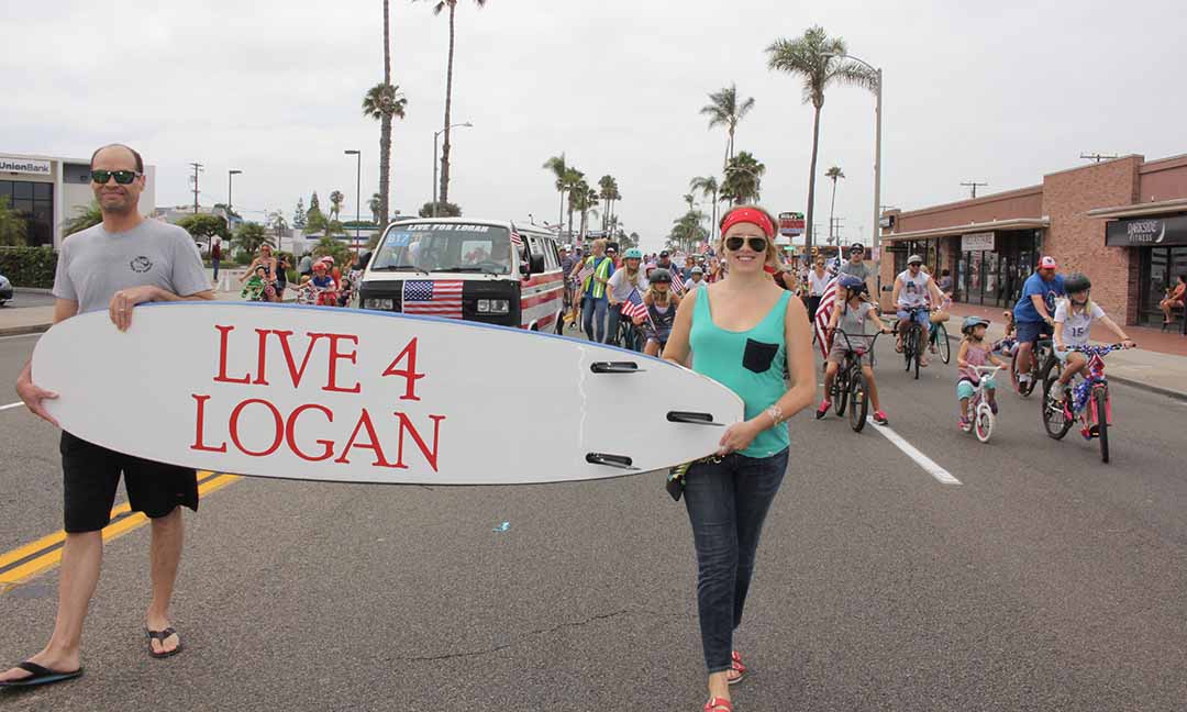 Right, Bess Singleton, co-organizer of the Live 4 Logan bike coalition, carries the group’s entry banner. The Live 4 Logan bike coalition was formed last November. Photo by Promise Yee