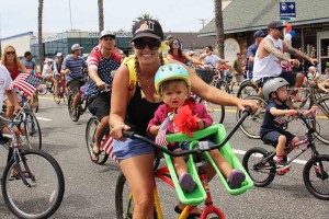 Holli Vanderslice, and Hillary Vanderslice, 2, ride with the Live 4 Logan bike coalition. The parade entry was met with roars of applause from spectators.