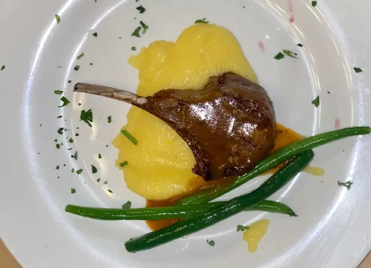 Unshackled at Vittotio's Prisoner wine dinner: Grilled New Zealand lamb chop atop a bed of polenta with grilled French beans and dijon rosemary au jus. 