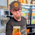 Manager Travis Hudson offers a beer The Brewers Tap Room in Encinitas.