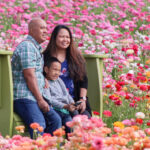 A family gets a picture taken on March 12 at The Flower Fields at Carlsbad Ranch.