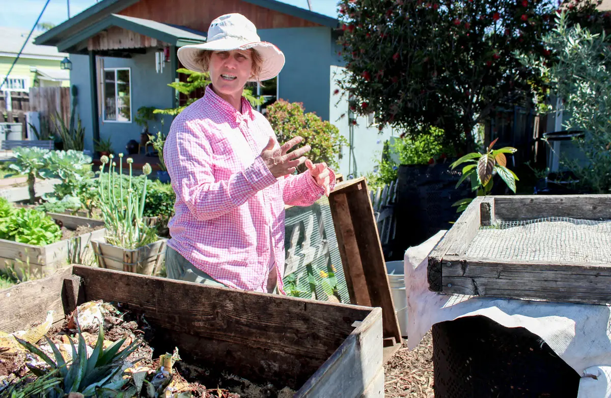 Wendy Miller, a volunteer at Food2Soil Composting Collective, digs through the dirt at her home in San Diego. Miller’s front yard is one of many compost drop-off stations for Food2Soil subscribers across the county.