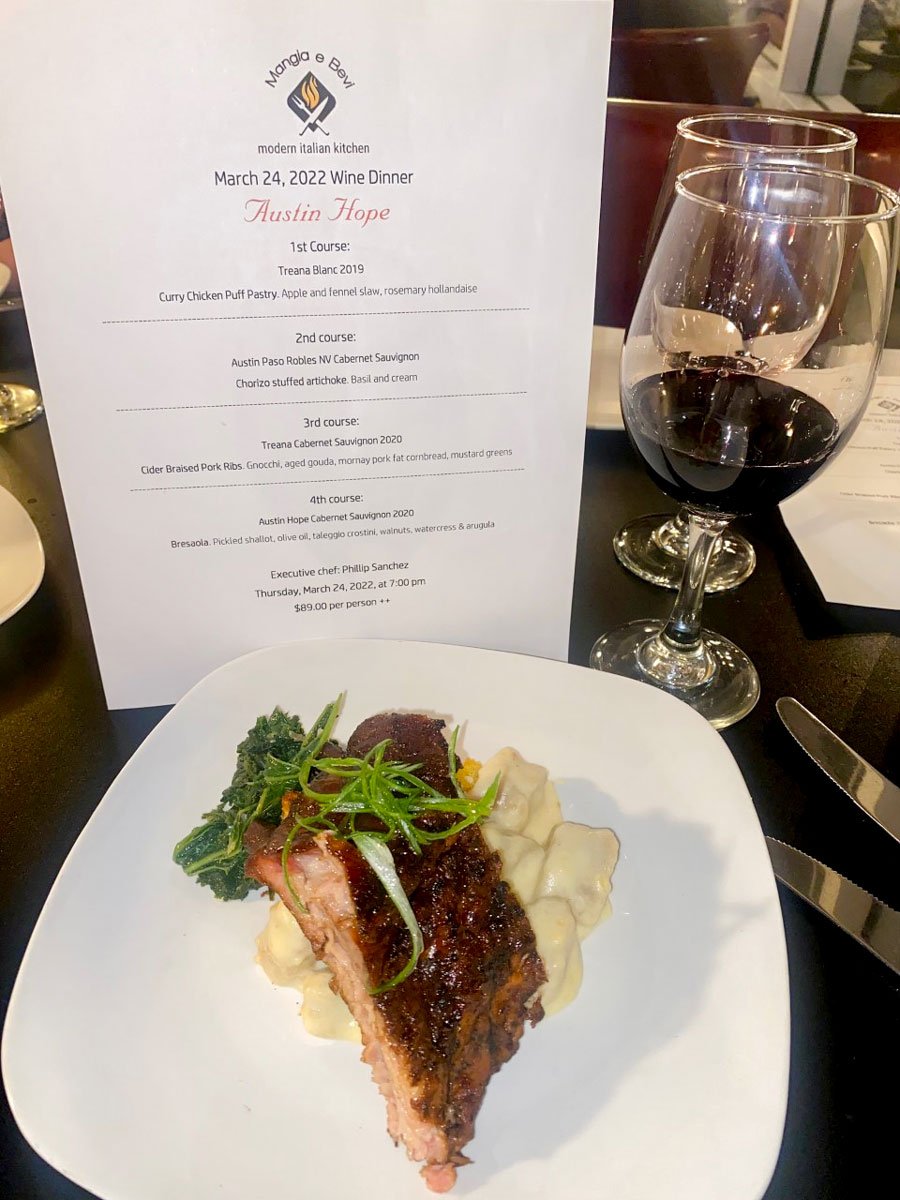 Cider Braised Pork Ribs with Gnocchi, cornbread, and mustard greens paired with 2020 Austin Hope Cabernet Sauvignon.