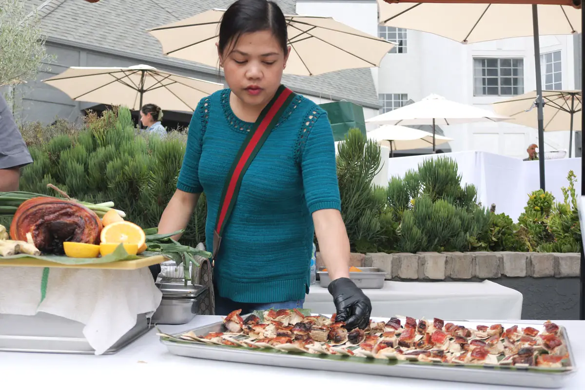 Jane Punzal, of San Marcos restaurant Litchi and Mary, prepares small plates of Filipino pork belly on Sunday at the Hilton Del Mar during the 25th annual Meet the Chefs event benefiting Casa de Amparo.