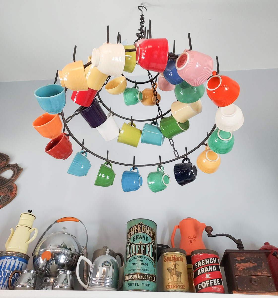 A chandelier of colorful coffee cups hangs near vintage coffee cans and equipment at Moonlight Coffee & Tea in Encinitas.  Photo by Ryan Woldt