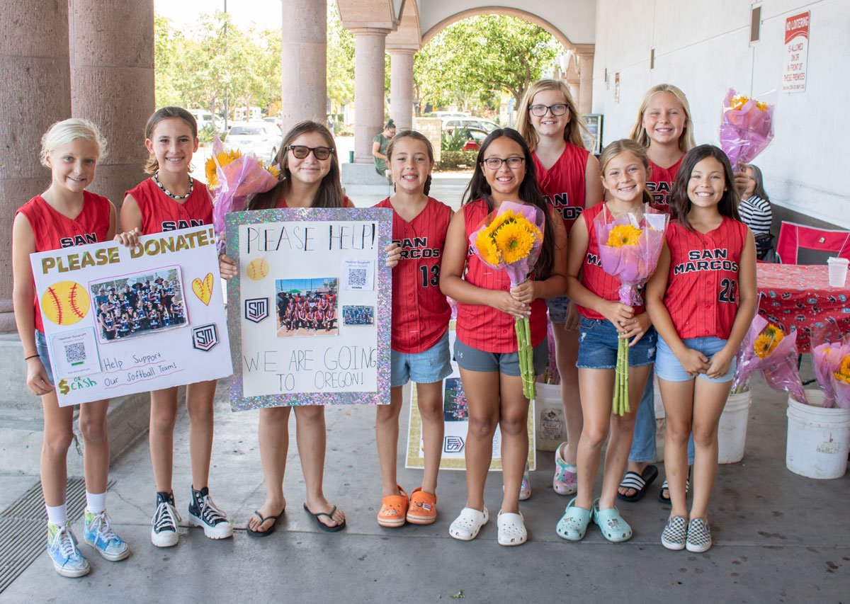 The San Marcos Girls Softball 10U All Star team sells flowers at Albertsons in San Marcos to raise funds for its upcoming trip to Salem, Ore., to compete at Western Nationals. Photo by Laura Place