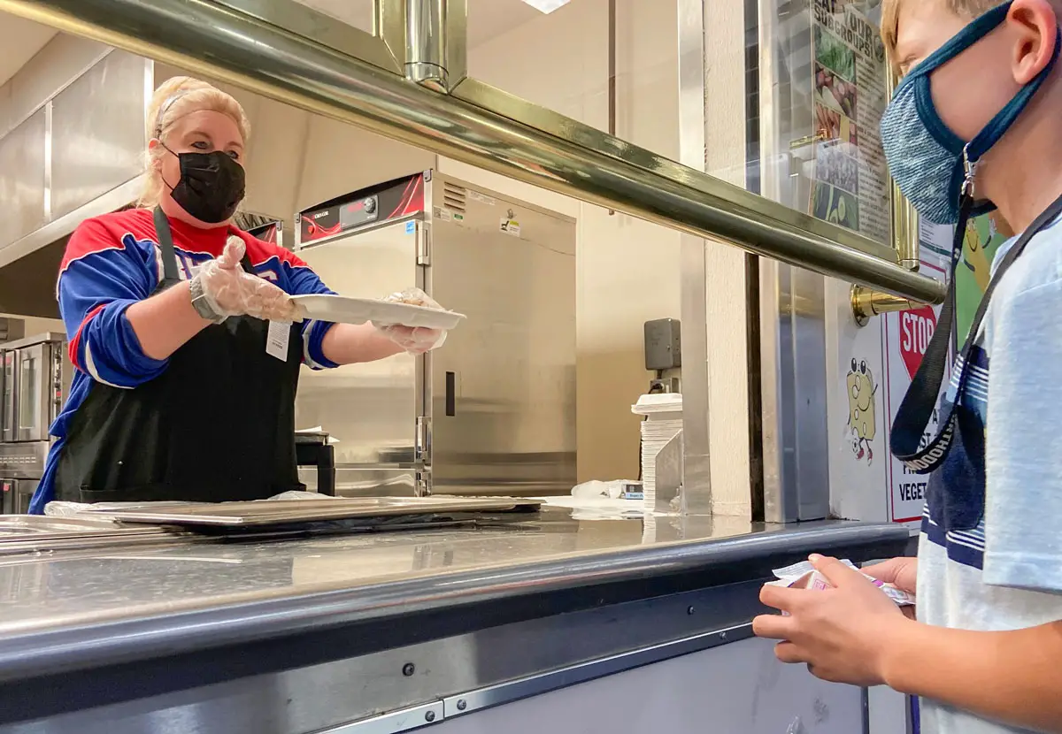 Marni Shelton serves meals to students in the San Marcos Unified School District last year. The district will offer two free meals a day to all students beginning this year under new state funding. Photo courtesy of San Marcos USD