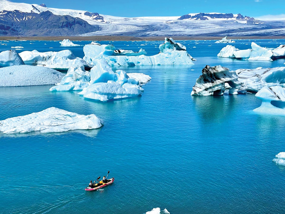 Kayakers paddle toward icebergs at Jokulsarlon glacier lagoon in Iceland. It is one of the stops on the annual Iceland tour offered by GeoTours through the Anza-Borrego Desert Natural History Association. Photo by Laurie Brindle
