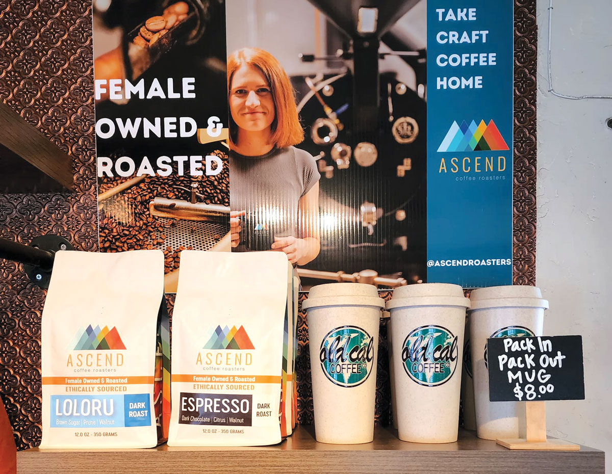Erin Nenow, co-owner of the cafe, launched Ascend Roasters during the early days of the coronavirus pandemic. Nenow is shown on placard in background. Photo via Facebook/Old Cal Coffee