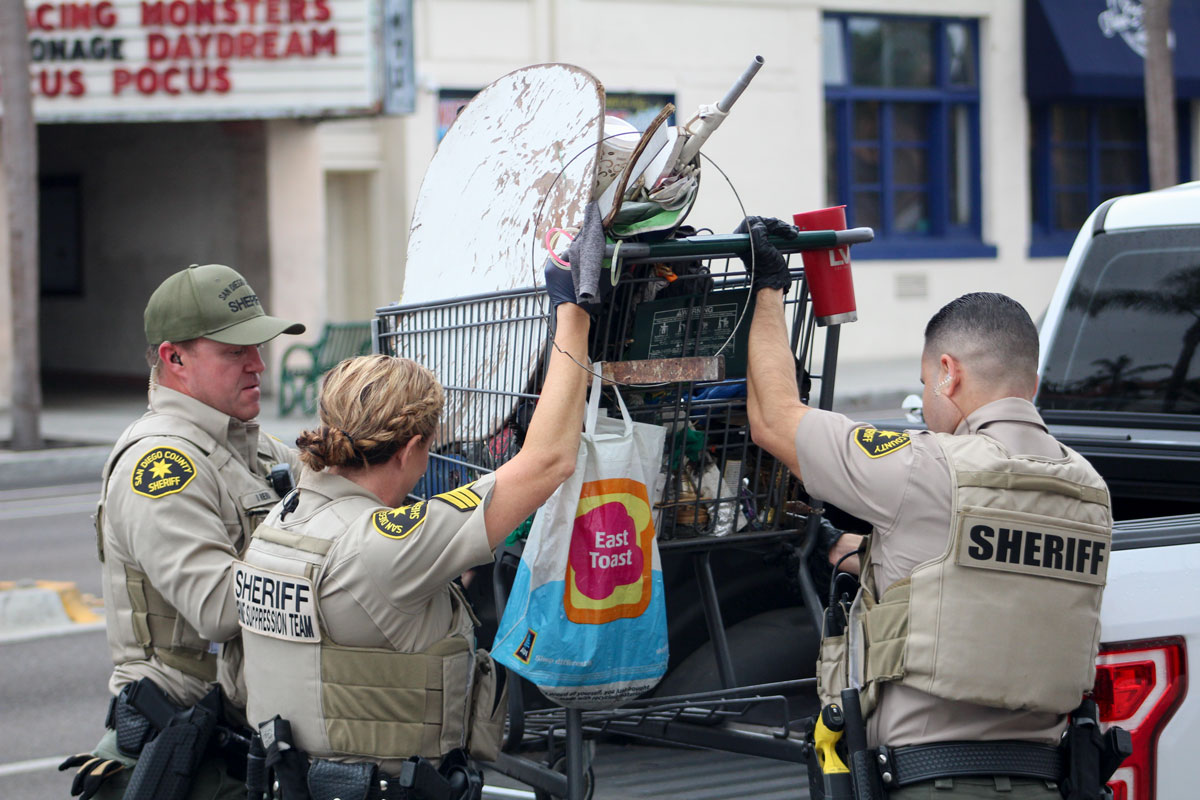 Sheriff's deputies impound a grocery cart filled with a transient man's belongings after the man was arrested in connection with a shooting Thursday morning in Encinitas. Photo by Jordan P. Ingram