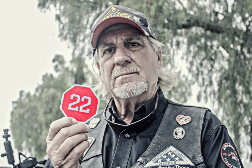 Steven Crouch, a Carlsbad resident and Coast Guard veteran, holds up a “22” patch that once represented the number of daily veteran suicides, according to a 2013 report by the Department of Veterans Affairs. Photo by Jordan P. Ingram